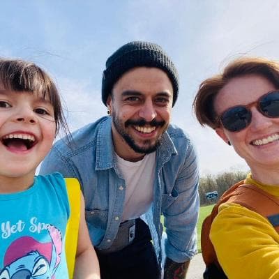 Seth Carrino outdoors, smiling with two people beside him